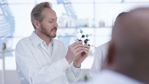 Doctors discussing over molecule model in lab at hospital Stock Footage 106793743