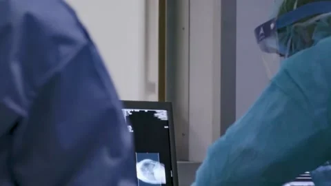 Doctors examining lung images from a tomograph Stock Footage 133376726