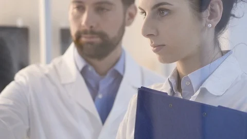 Doctors examining a patient's x-ray and discussing Stock Footage 86683045