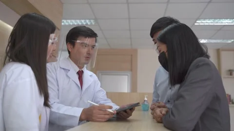 Doctors with face mask shield talking with the patients at reception contour. Stock Footage 138789879