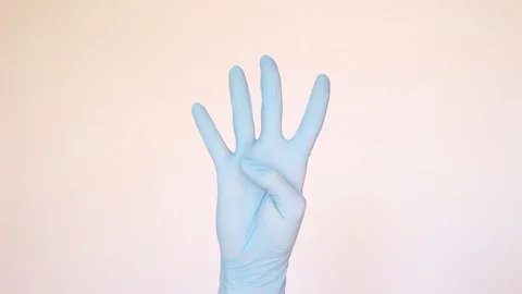 Doctor's hand in blue glove counting to five Stock Footage 96239747