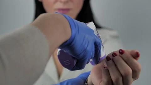 Doctor's hand in gloves to measure the temperature on the pulse with a non Stock Footage 144186766
