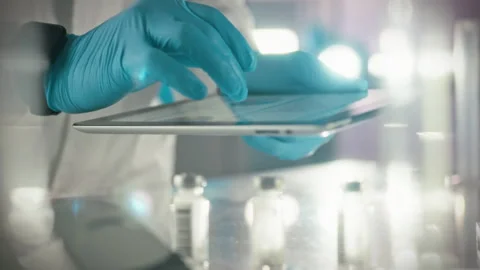 A doctors hand interacts with a touchscreen tablet checking the electronic d Stock Footage 331451926
