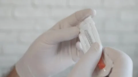 Doctor's Hand Preparing a Vaccination with a Sterilized Syringe.  Immunization Stock Footage 328968187