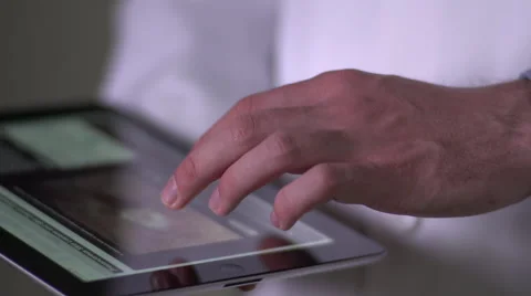 Doctor's hand touching ipad, tight shot, left side Vídeo Stock 55302545