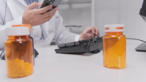 Doctor's hand typing computer keyboard and chat message from mobile phone. Stock Photos