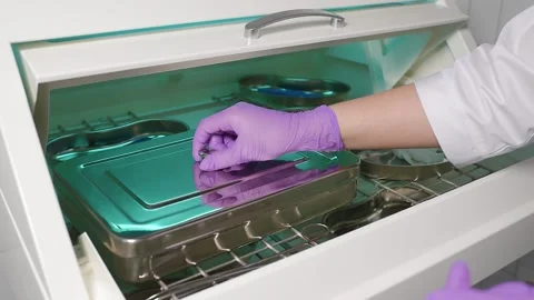 Doctor's hands in blue rubber gloves taking sterile instruments out of an Stock Footage 152155937