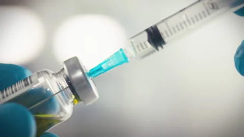 The doctors hands clad in protective nitrile gloves carefully pierce a seale Stock Footage 331363580
