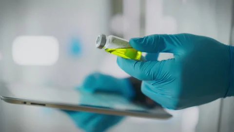 Doctor's hands in close-up doing drug comparison while holding medicine bott 스톡 동영상 263624161
