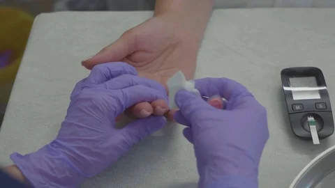 Doctor's hands in gloves take finger blood test of female patient. Stock Footage 81068564