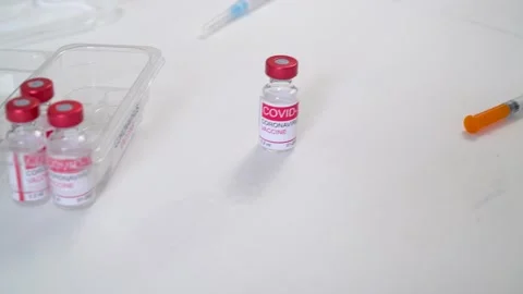 Doctors hands in gloves take vials with coronavirus vaccine and syringe Vídeos de archivo 150458612