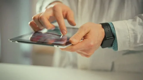 Doctors hands hold an electronic tablet zooming into panoramic x-ray on the Video stock 333501179