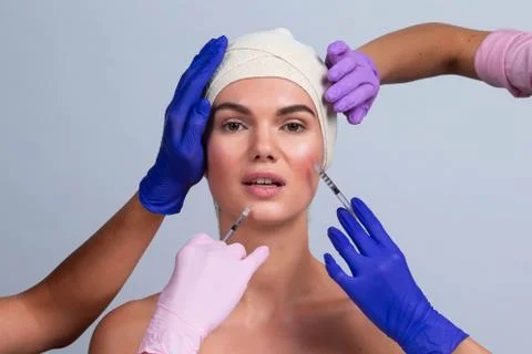 Doctors hands making injection in face Stock Photos