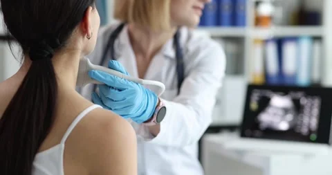 Doctor's hands with a probe on a woman's neck Stock Footage 245807931
