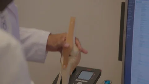 Doctors hands showing a replica knee Stock Footage 103867358