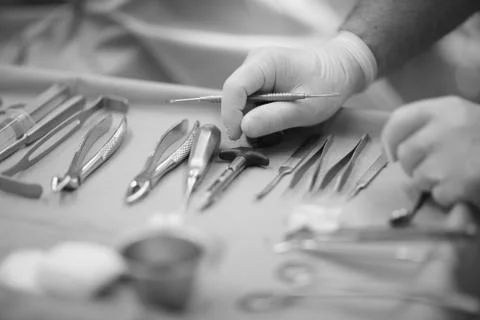 Doctor's hands on the table with the tool in the operating room dental clinic Stock Photos
