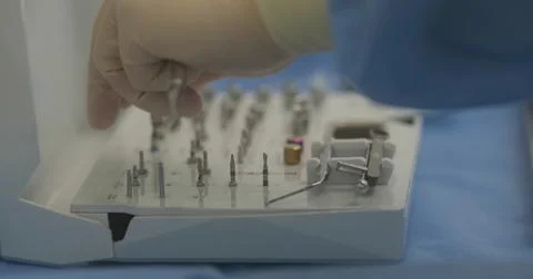 Doctor's hands with a working tool. Preparation and process of dental treat.. Stock Photos