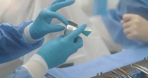 Doctor's hands with a working tool. Preparation and process of dental treat.. Stock Photos