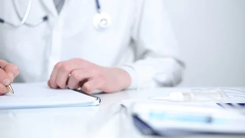 Doctor’s hands write medical report or diagnosis at the clinic’s work table. Stock Footage 126006607
