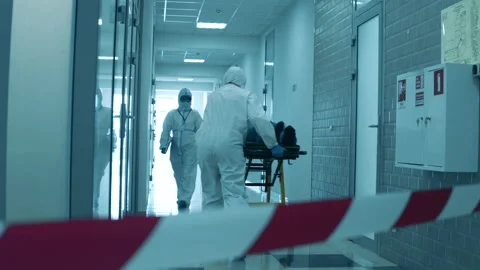 Doctors in hazmat suits walking along a hall on quarantine Video stock 130741237