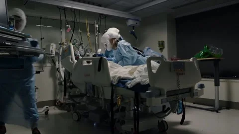 Doctors in a hospital in protective suits doing procedures for a patient. Pandem Stock Footage 143161842