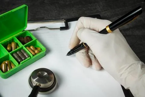 Doctor's kit: stethoscope, container with pills and pen with papers Stock Photos