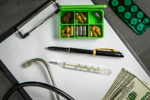 Doctor's kit: stethoscope, container with pills and pen with papers Stock Photos
