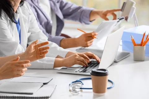 Doctors with laptop and tablet computer working at table in clinic, closeup 스톡 사진