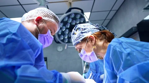 Doctors leaned over the patient at operation.  Stock Footage 291713857