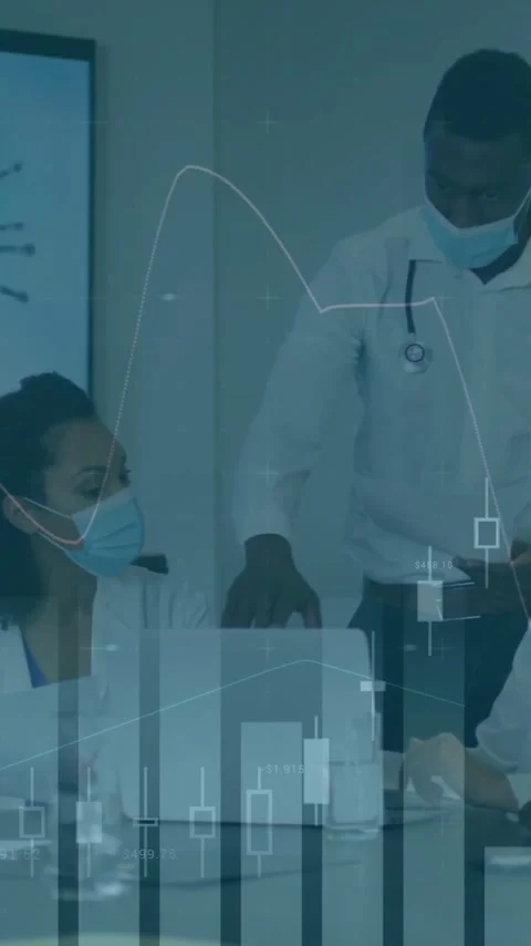 Doctors in meeting with financial data processing animation over them Stock Footage 343028660
