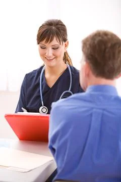 Doctors: Nurse Going Over Form with Patient Stock Photos