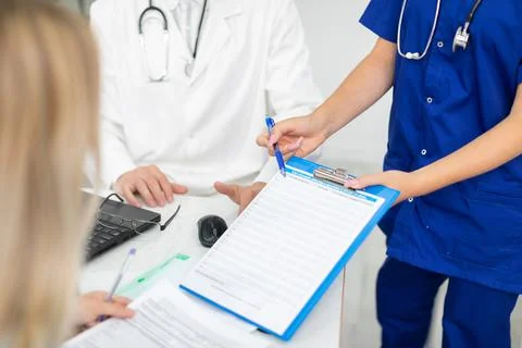 In the doctor's office, doctors explain how to fill out the declaration on COVID 写真素材