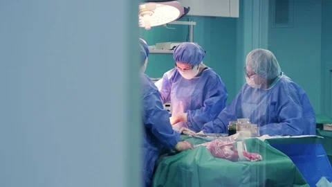 Doctors in an operating room operating a patient Stock Footage 128747868