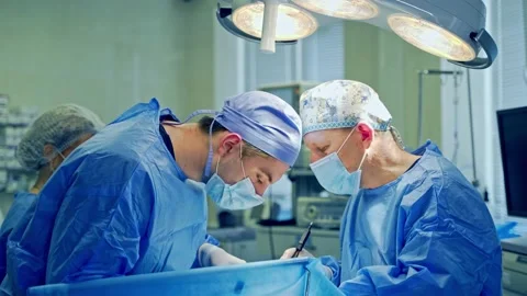Doctors perform an operation using surgical instruments. Stock Footage 130510079