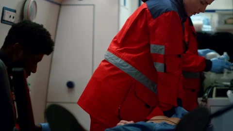 Doctors performing CPR of man in ambulance. Paramedics providing heart massage Stock Footage 166876600
