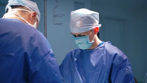 Doctors in protective masks during operation. Stock Footage 125894845