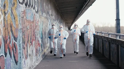 Doctors with protective suits and respirators running outdoors, coronavirus Stock Footage