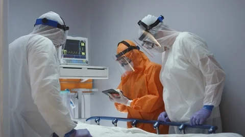 Doctors in Protective Suits Consult Coronavirus Patient's Status Stock Footage 126034052