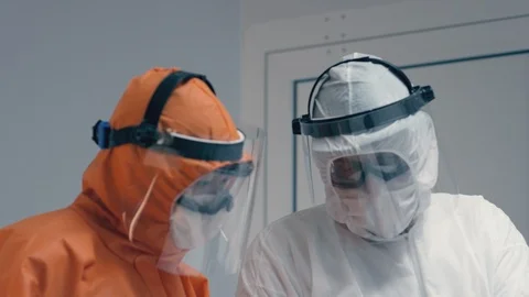 Doctors in Protective Suits Consult Coronavirus Patient's Status - Close Up Stock Footage 126205271