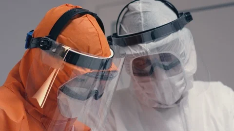 Doctors in Protective Suits Consult Coronavirus Patient's Status Stock Footage 126206079