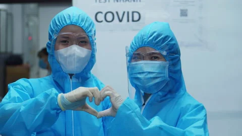 Doctors in protective suits during the epidemic show signs of life and heart in Stock Footage 165318585