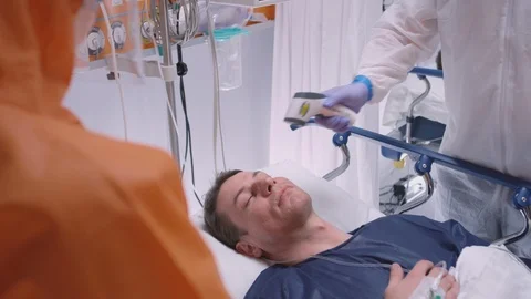 Doctors in Protective Suits Taking Coronavirus Patient's Temperature Stock Footage 126521886