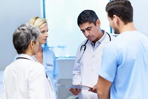Doctors, reading and group with paperwork in hospital, teamwork and discussion Stock Photos