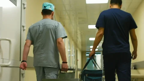 Doctors rush along the clinic corridor with medical equipment Video stock 101011425
