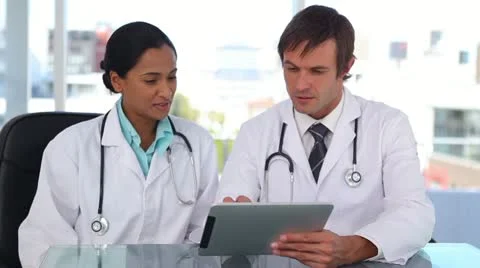 Doctors smiling while using a tablet computer Stock Footage 10860550