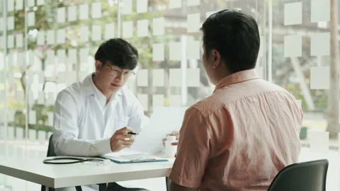 Doctors submit patient records on sticky notes and talk to patients about med Stock Footage 165194409