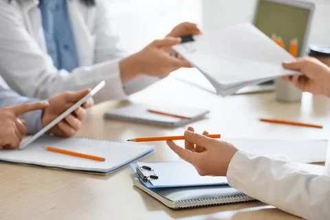 Doctors with tablet computer and notebooks working at table in clinic, closeu 写真素材