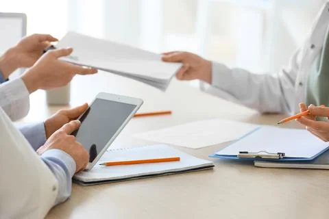 Doctors with tablet computer and notebooks working at table in clinic, closeu Stock Photos