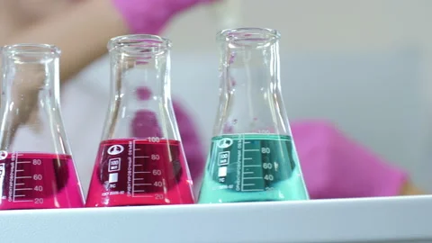 Doctors take tests from flasks with multi-colored drugs in the laboratory Vídeos de archivo 141041182