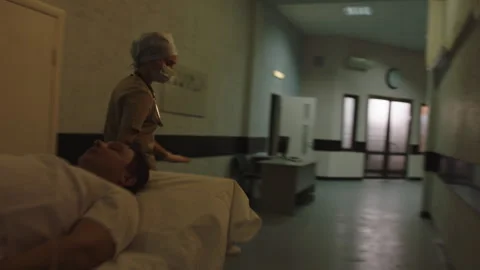 Doctors taking the ill patient to the other part of the hospital through the Stock Footage 283147551